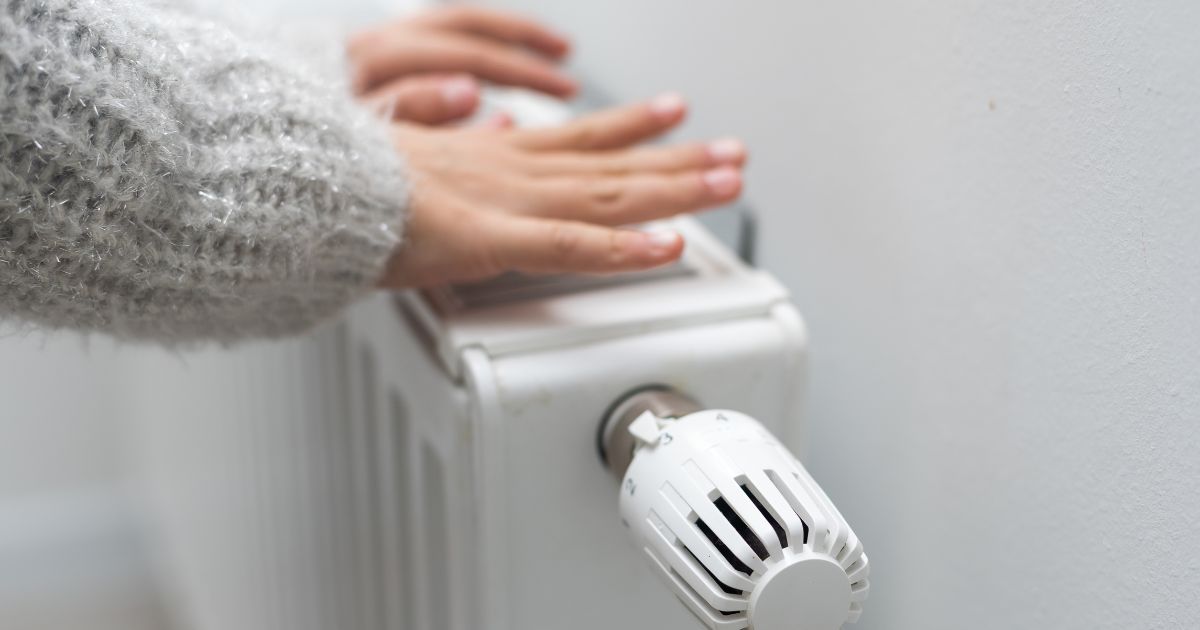 Handen warmen aan verticale radiator