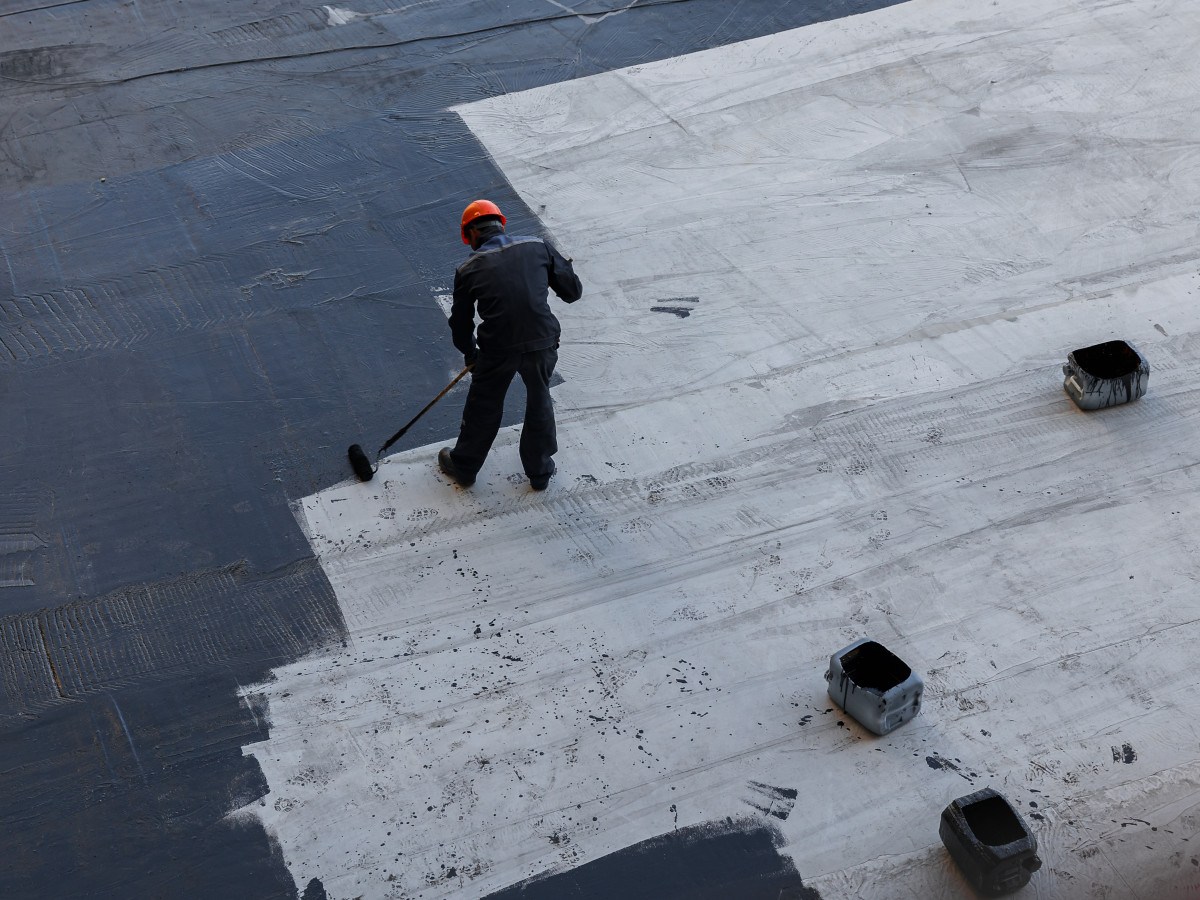 bitumen wordt aangebracht op plat dak