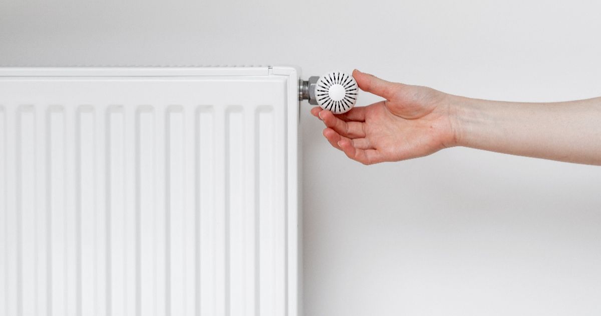 Witte radiator wordt aangepast met draaiknop